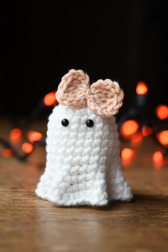 A small girl crochet ghost wearing a pink bow