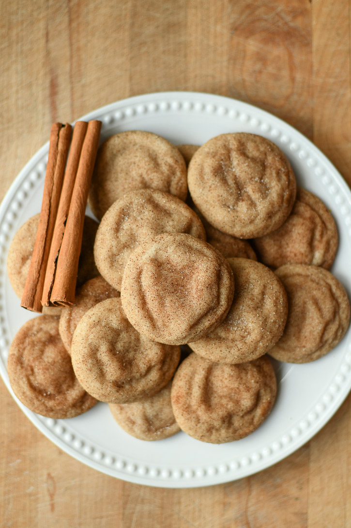 Brown Butter Snickerdoodles and cinnamon sticks on a white plate