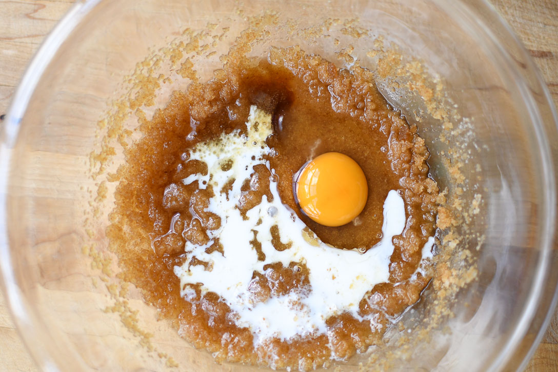 Adding egg, vanilla, and milk to sugar and butter mixture