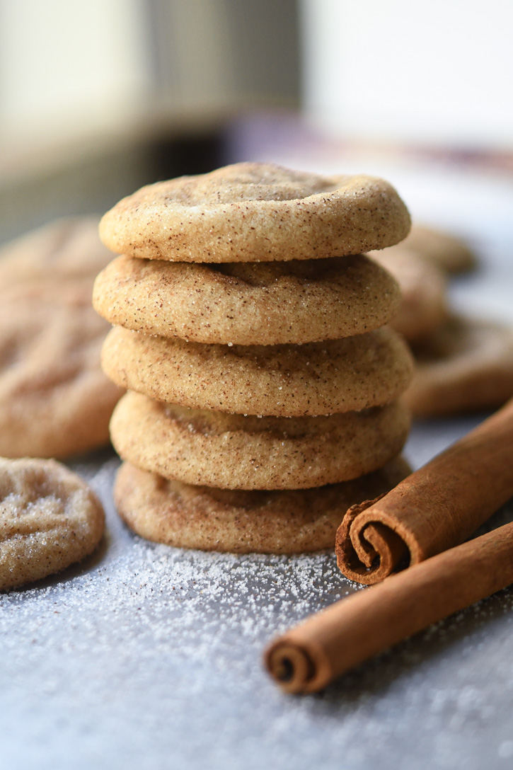 Snickerdoodles stacked decoratively on a baking tray