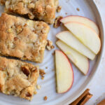 Apple Brownies on a plate with slices of Honey Crisp Apple and cinnamon sticks