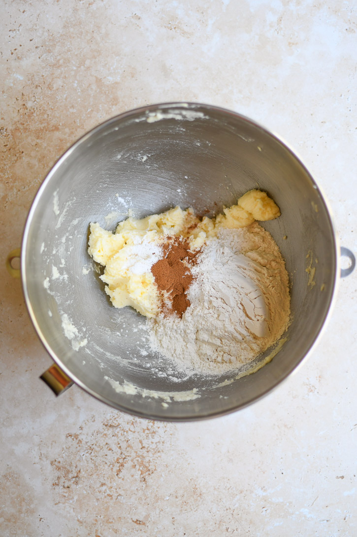 A mixing bowl with apple brownie batter plus flour and cinnamon