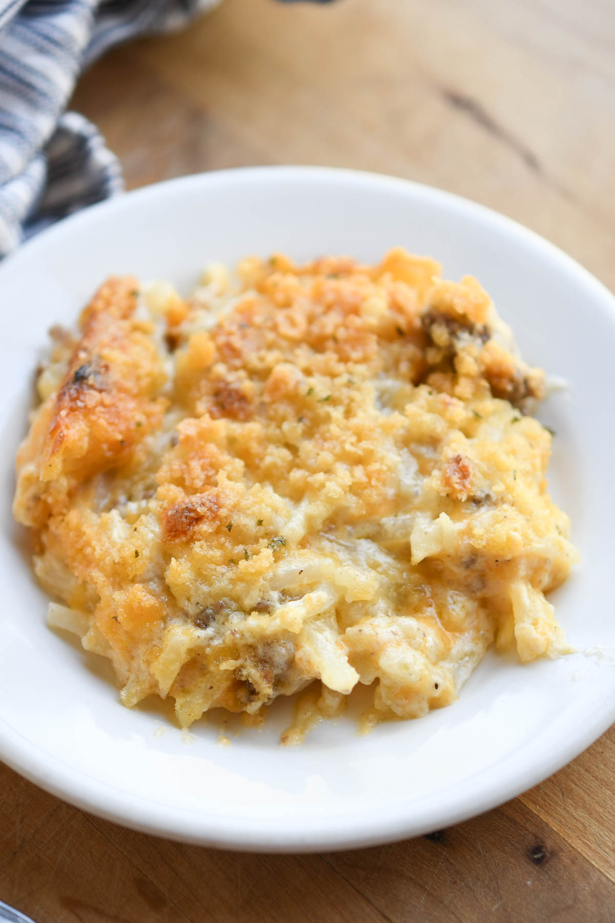 A close up photo of a plate of hashbrown and ground beef casserole showing the texture of the meal