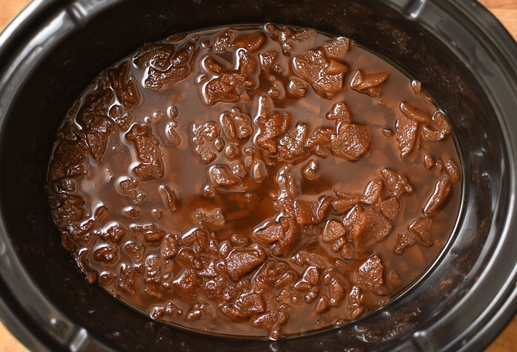 A crock pot with pear butter mixture after being cooked for several hours.