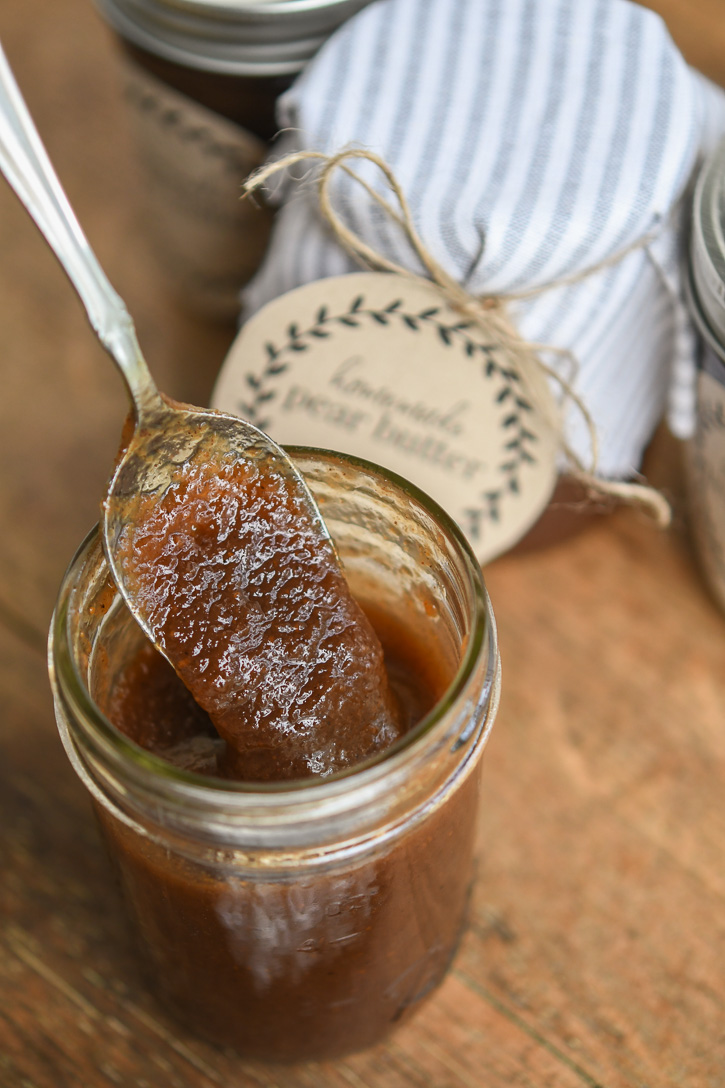 A jar with a spoon of pear butter 