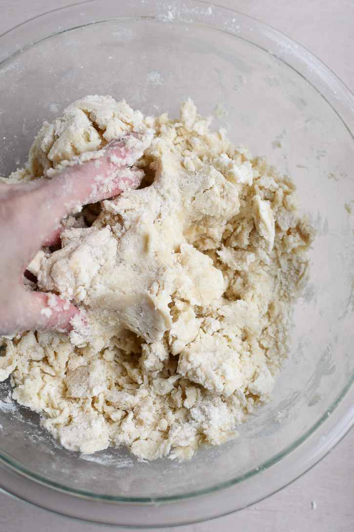 The cookie dough halfway through mixing, showing a course, crumbly texture 