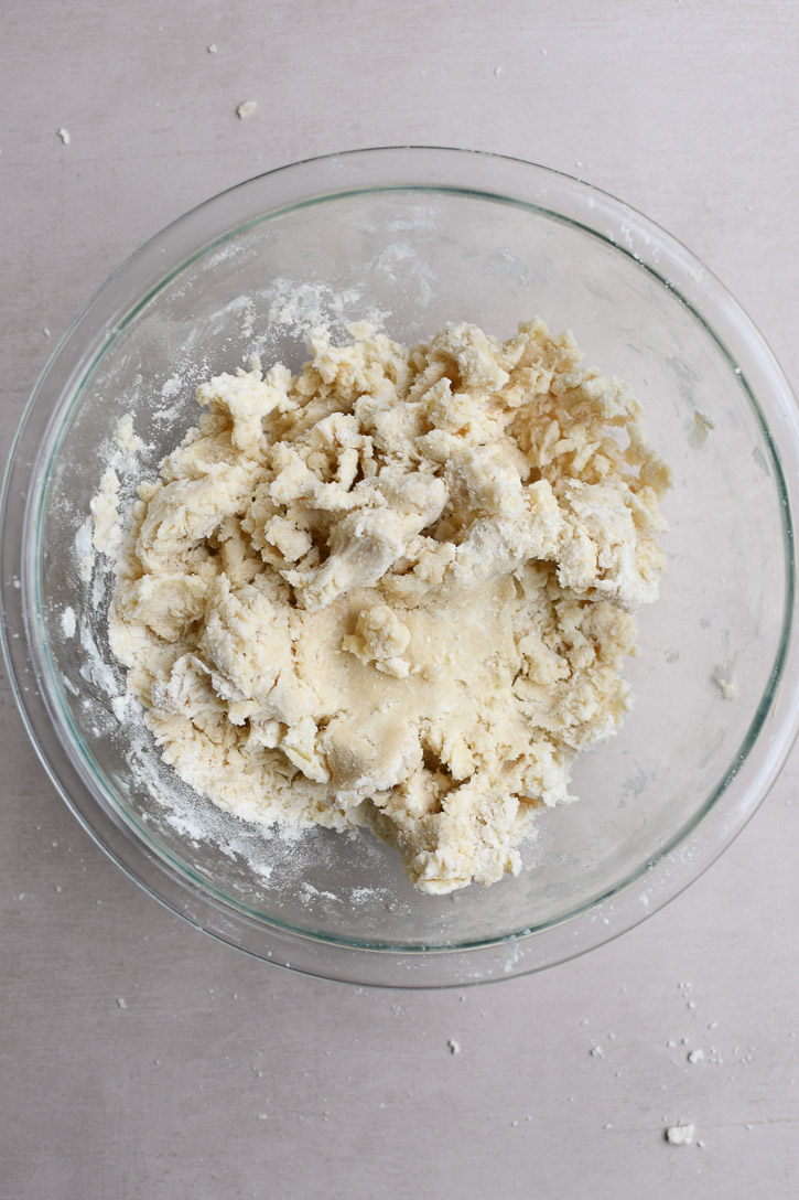 The cookie dough halfway through mixing, showing a course, crumbly texture 