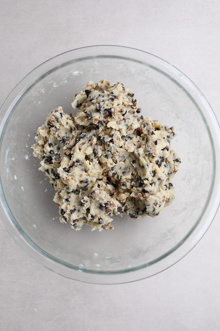 A bowl of dough after the chopped pecans and mini chocolate chips have been thoroughly incorporated