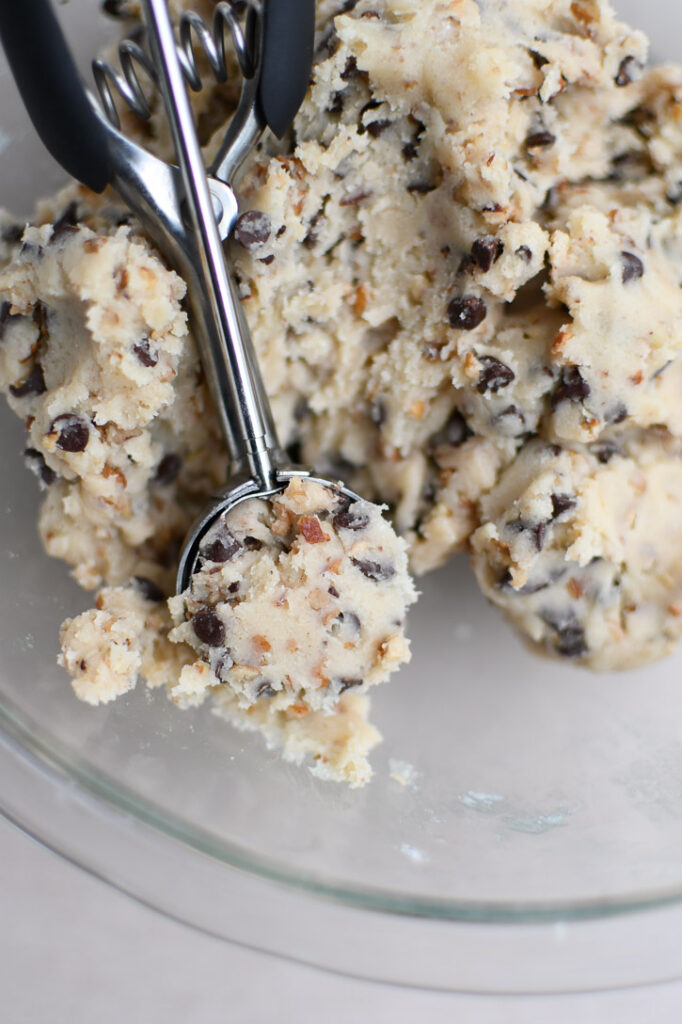 A close up of the snowball cookie dough in a tablespoon size cookie scoop