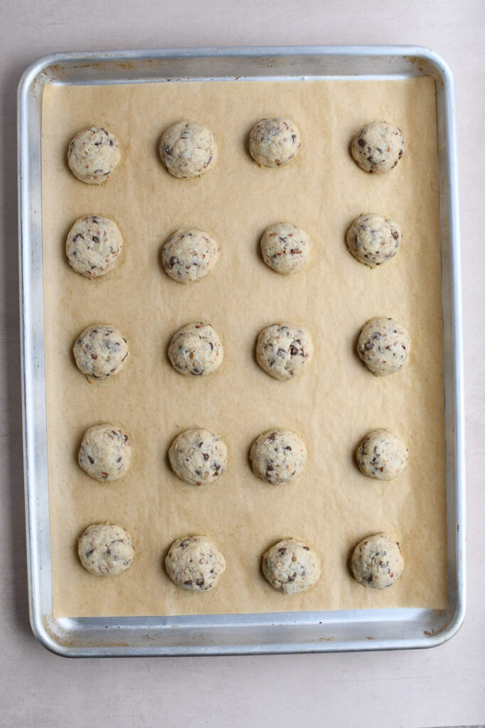 A cookie sheet with snowball cookies fresh from the oven 