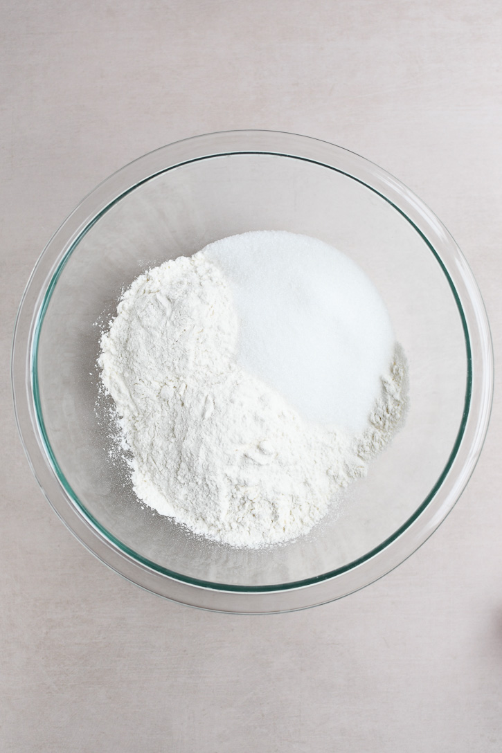 A glass bowl with flour and sugar 