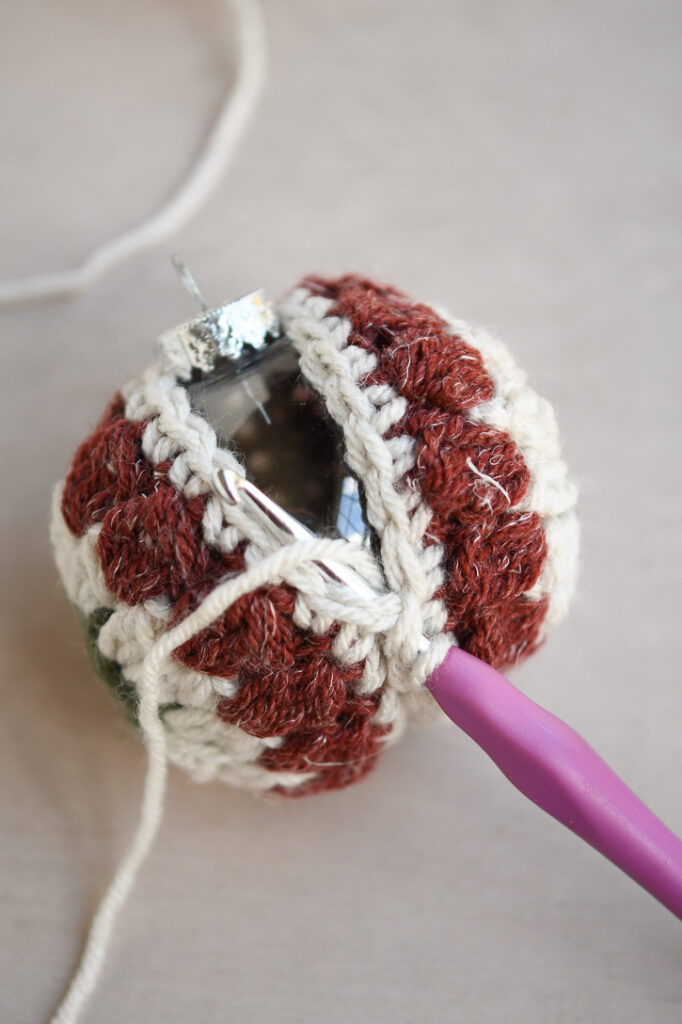 Continuing to slip stitch the edges with the plastic ornament inside