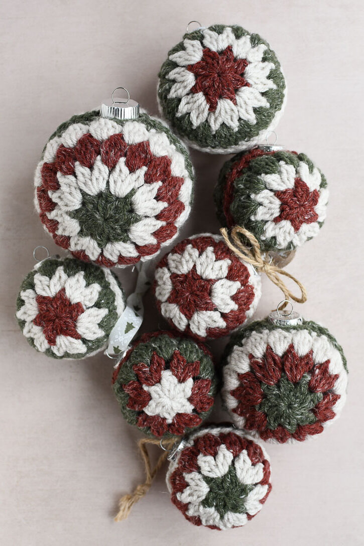 A group of completed crochet Christmas ornaments with different color combinations and size ranges