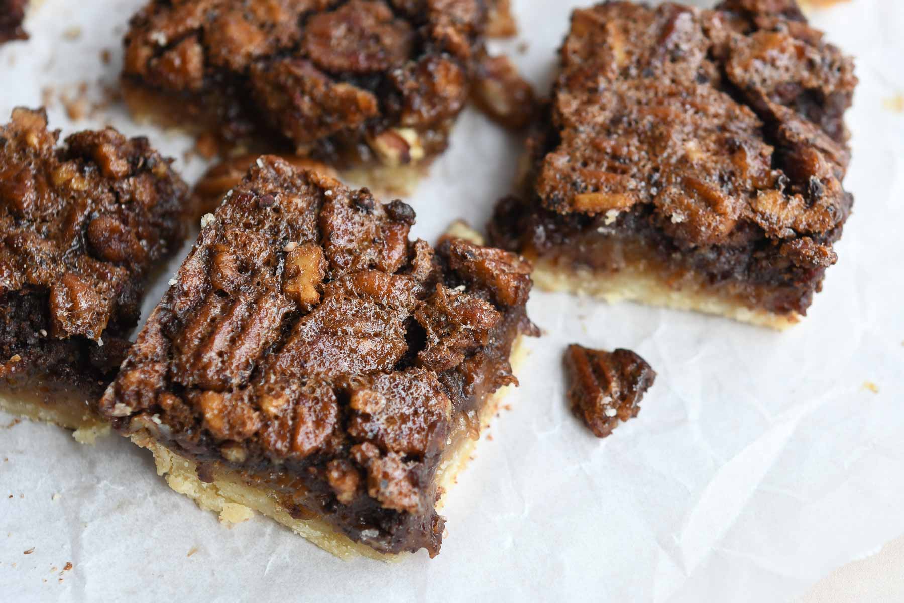 Chocolate Pecan Pie Bars cut into squares on parchment paper