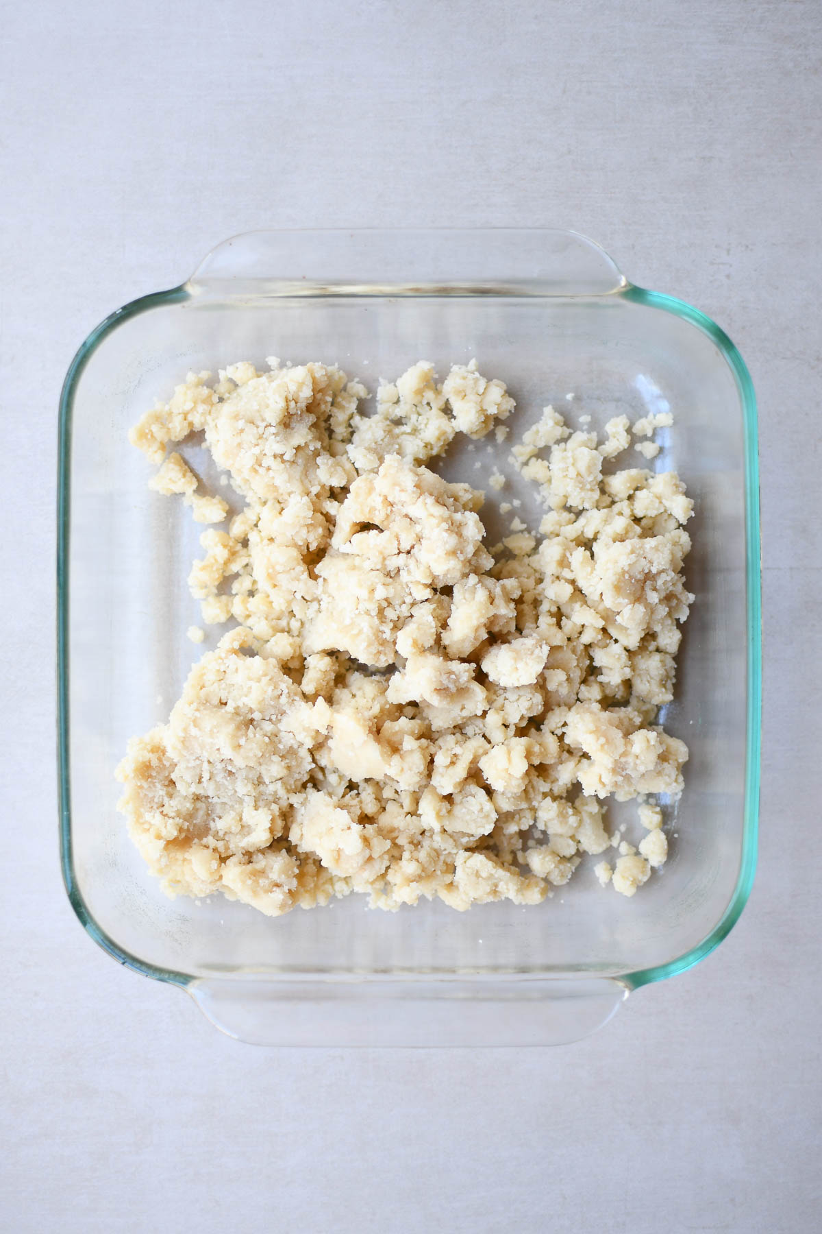 The shaggy shortbread dough in an 8x8 pan before being pressed in