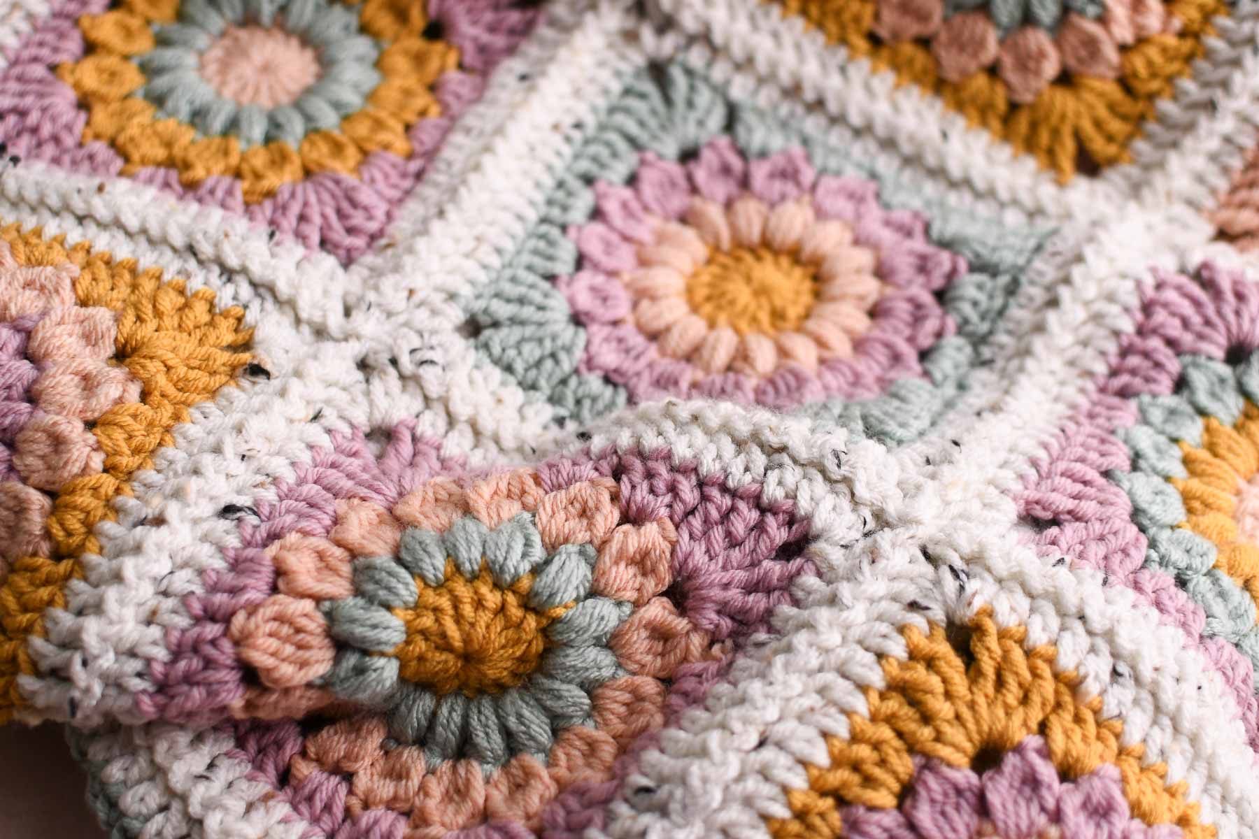 A close up showing the colors and textures of the sunburst granny square blanket