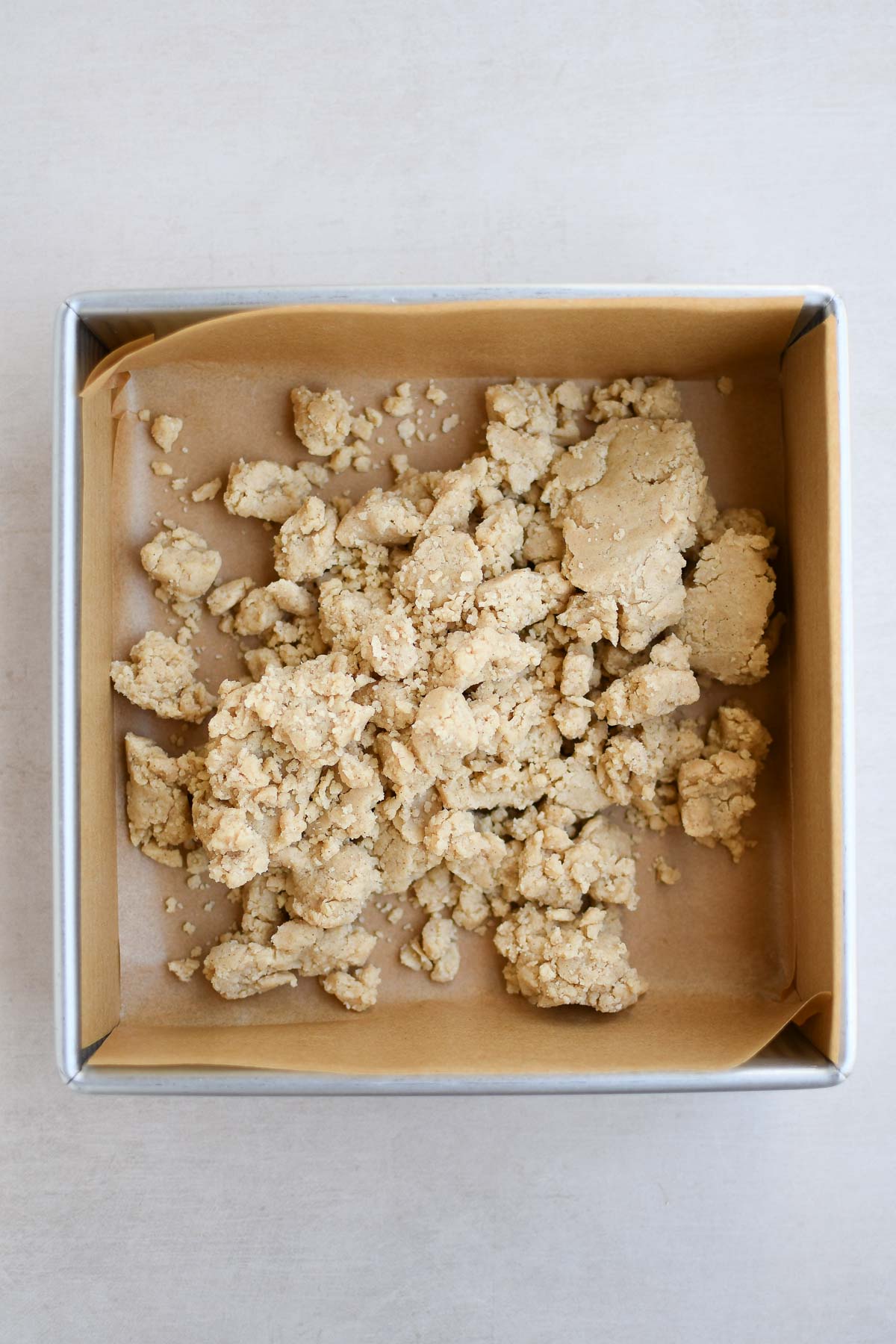 A clumpy shortbread dough before pressing into an 8x8 pan 