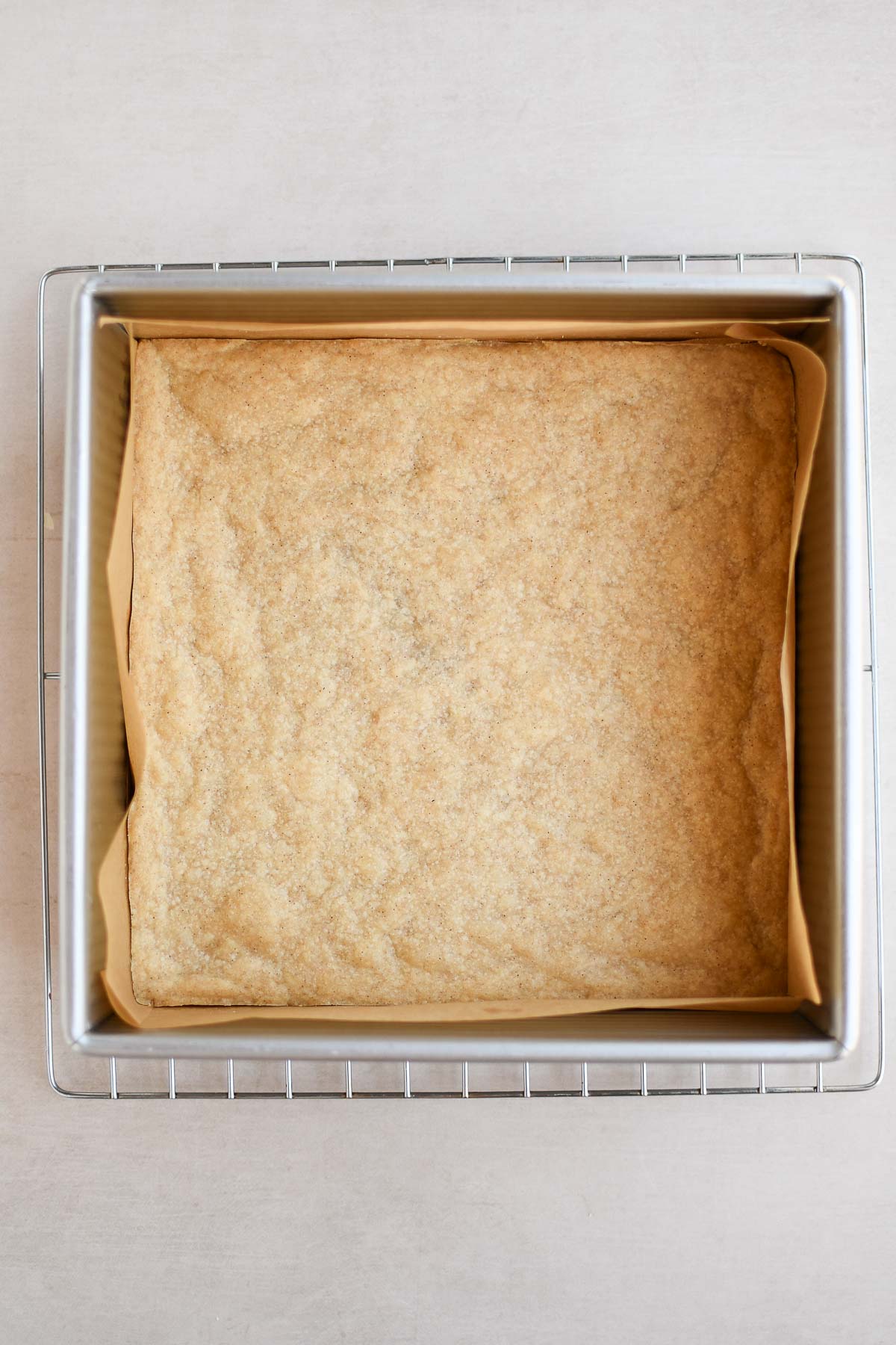 A baked shortbread crust cooling on a wire rack